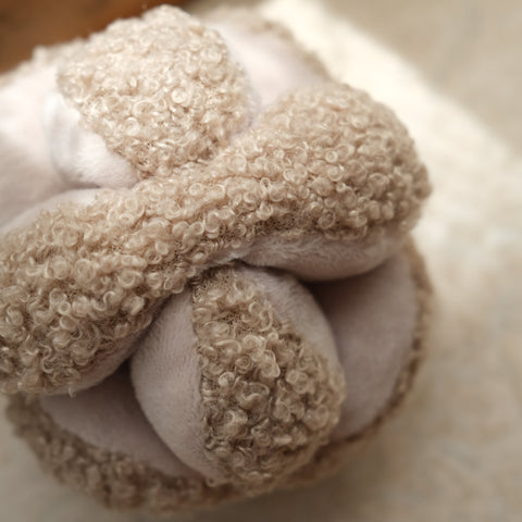 Tan sherpa fleece covers a plush dog toy.