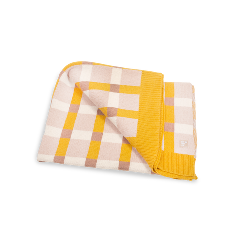 Folded knitted blanket showcases a bold yellow, white, and tan checkered pattern.